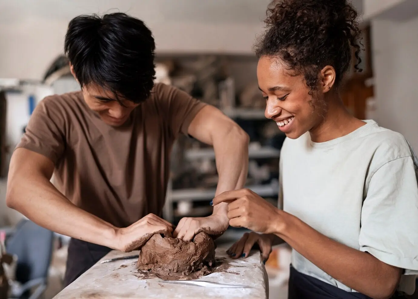 Frontalansicht lächelnder Menschen beim Tonmodellieren