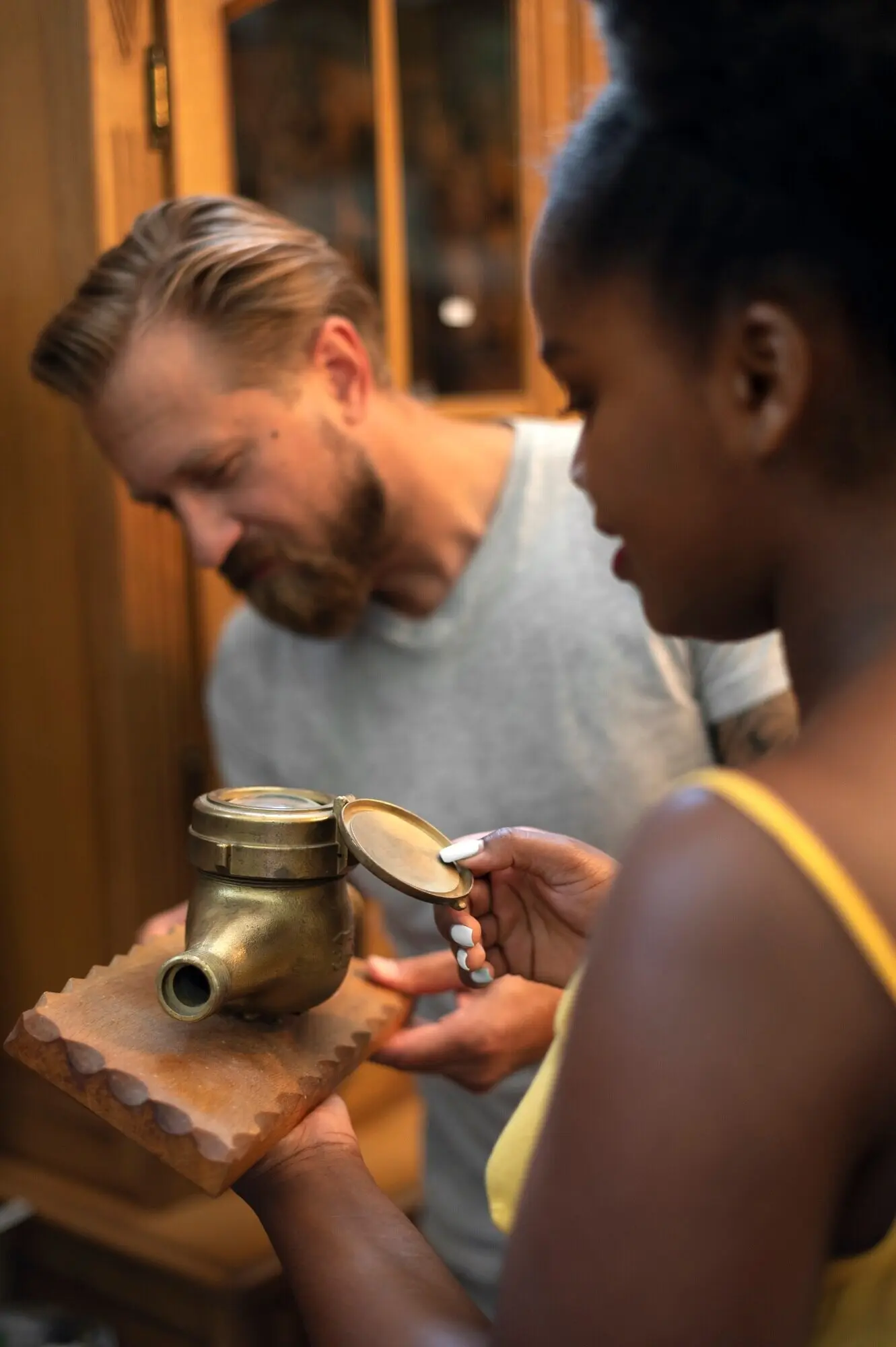 Seitenansicht von Menschen, die einen alten Gegenstand betrachten.